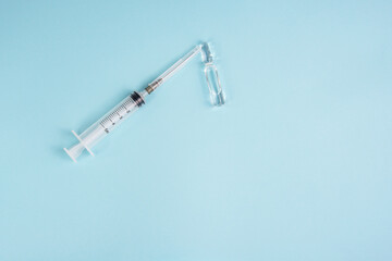 Syringe and ampoule on blue background