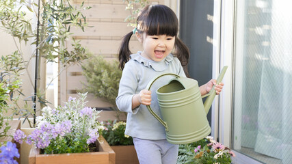 ベランダガーデニングで花に水やりする子供