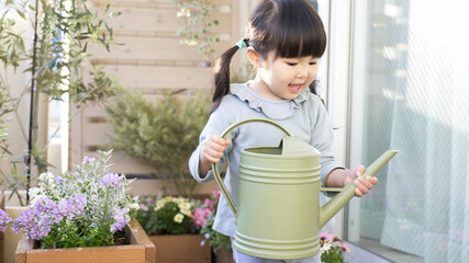 ベランダガーデニングで花に水やりする子供