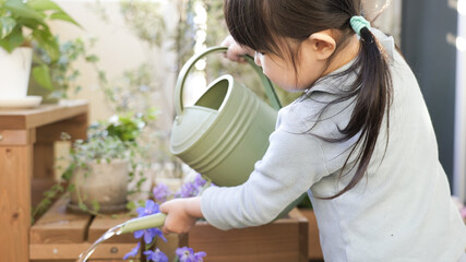ベランダガーデニングで花に水やりする子供