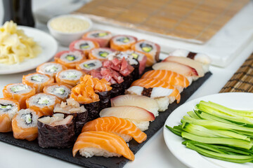 Sushi rolls prepared by professional asian chef with traditional Japanese ingredients. Salmon fish, rice, vegetables, sesame seeds.  Sushi cooking and seafood making concept
