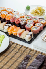 Sushi rolls prepared by professional asian chef with traditional Japanese ingredients. Salmon fish, rice, vegetables, sesame seeds.  Sushi cooking and seafood making concept
