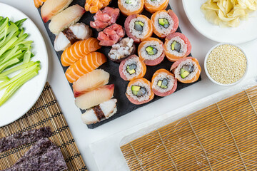 Sushi rolls prepared by professional asian chef with traditional Japanese ingredients. Salmon fish, rice, vegetables, sesame seeds.  Sushi cooking and seafood making concept