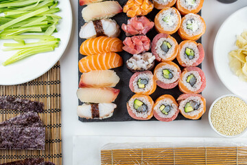 Sushi rolls prepared by professional asian chef with traditional Japanese ingredients. Salmon fish, rice, vegetables, sesame seeds.  Sushi cooking and seafood making concept