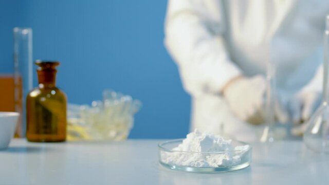 Chemical laboratory food supply. GMO Genetically modified products in the laboratory. A lab technician in a white coat holds nitric acid in his hand.