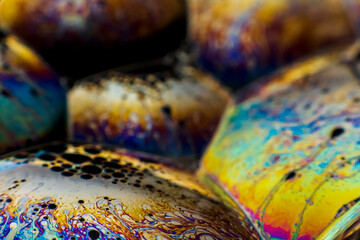 The colorful close-up surface of a soap bubble with weird psychedelic background and...