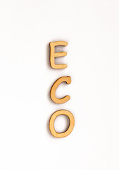 the vertical word "eco" from wooden letters isolated on white background, letters from natural materials for education, eco friendly logo or emblem