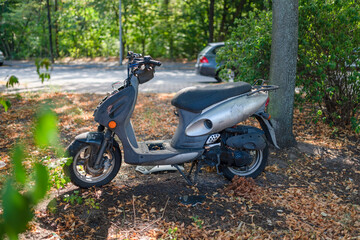 durch Vandalismus beschädigter Roller / Scooter auf einem Naturparkplatz, 