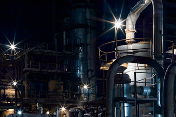 Night industrial petrochemical landscape. Reactors pipes and columns. Large-capacity production...