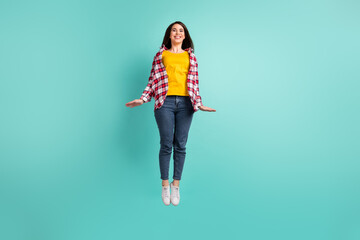 Full length photo of charming active young woman jump up air wear plaid shirt isolated on teal color background