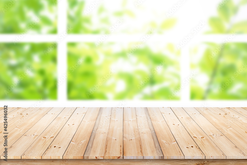 Poster empty wood table top on blur green leaf garden from window view in the morning. for product display 