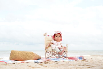 Asian baby girl sitting on beach chair.