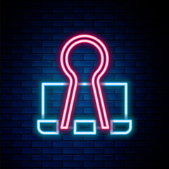 Glowing neon line Binder clip icon isolated on brick wall background. Paper clip. Colorful outline concept. Vector