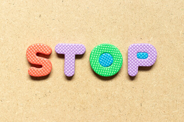 Foam alphabet letter in word stop on wood background