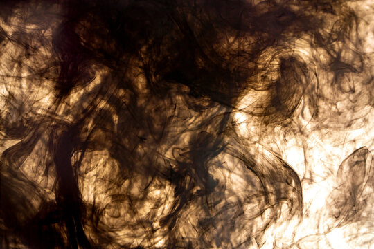 Abstract black ink swirling in water against bright background, dark smoky liquid texture, creative fluid art motion for dramatic backdrop and design