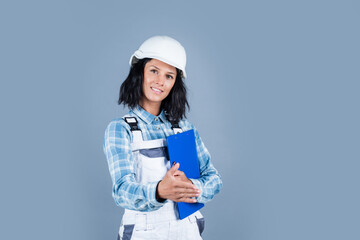 cheerful lady repairman in uniform on blue background, workshop