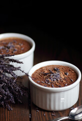 Chocolate vegan dessert - aquafaba mousse - egg free, non-dairy cocoa pudding or souffle decorated with lavender on dark moody background, closeup, vegan and vegetarian food concept