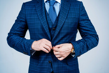 Buttoning up male vested blue suit with tie in formal fashion style grey background, formalwear