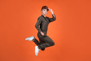 jumping woman in working uniform and hard hat running hurry up on work, building