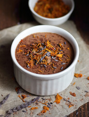 Chocolate vegan dessert - aquafaba mousse - egg free, non-dairy cocoa pudding or souffle decorated with lavender on dark moody background, closeup, vegan and vegetarian food concept