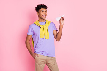 Photo of young handsome happy smiling afro man look copyspace hold little paper plane isolated on pink color background