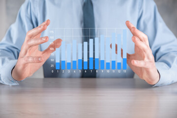 Businessman man holding a graph with positive profits growth. plan graph growth and increase of chart positive indicators in his business.more profitable and growing