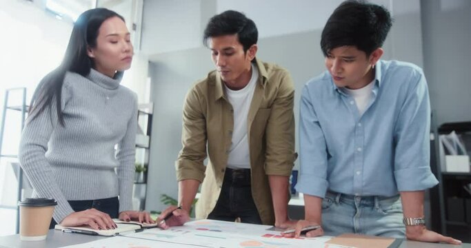 Young Asian business financial team work together in project brainstorm meeting. Cooperate teamwork, strategy planning, small business startup company, or office coworker collaborate concept