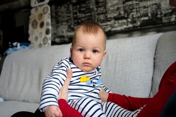 Portrait of cute little baby in pajamas holding by her grandmother