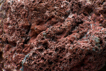 Close up of a red patterned volcanic rock. Background texture of a stone 