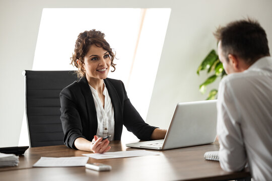 Portrait of a smiling businesswoman talking to a client.