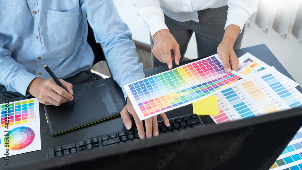 Aufkleber graphic designer or creative working together coloring using graphics tablet and a stylus at desk wi