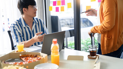Business team workers discussing work and prepare pizza and potato chips to sharing meal at lunch break for good relations in office.