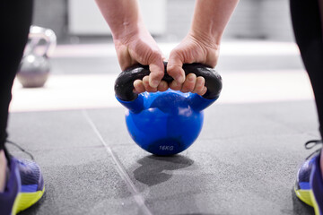 young girl holding a kettlebell. Sneakers. Sport. Crossfit