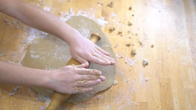 The girl rolls out the dough for pizza or cookies. Gluten-free cooking class. Cooking together at home with a parent.