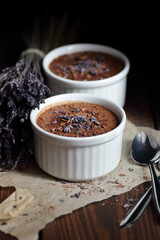 Chocolate vegan dessert - aquafaba mousse - egg free, non-dairy cocoa pudding or souffle decorated with lavender on dark moody background, closeup, vegan and vegetarian food concept