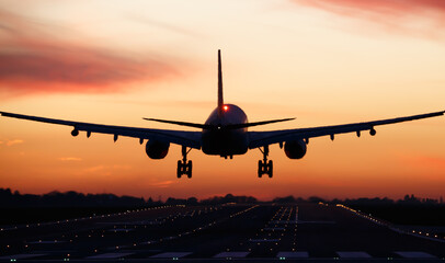 Fototapeta na wymiar Aeroplane landing at sunset