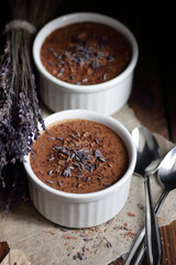 Chocolate vegan dessert - aquafaba mousse - egg free, non-dairy cocoa pudding or souffle decorated with lavender on dark moody background, closeup, vegan and vegetarian food concept