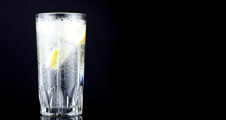 splash in a glass with lemon on a black background