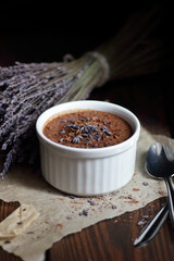 Chocolate vegan dessert - aquafaba mousse - egg free, non-dairy cocoa pudding or souffle decorated with lavender on dark moody background, closeup, vegan and vegetarian food concept