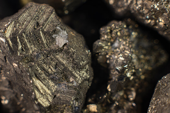 Macro photograph of natural pyrite crystal cluster, extreme close-up of iron sulfide mineral with metallic brass-yellow luster and cubic geological structure