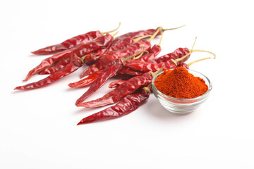Dried red chilli and powder in glass bowl on white background.