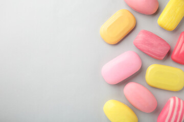 Different soaps in different soap dishes. A lot of solid soap for hygiene and cleanliness. Colorful soap and remnants are scattered on grey background.