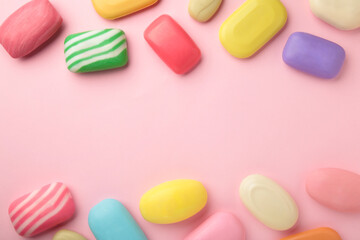 Different soaps in different soap dishes. A lot of solid soap for hygiene and cleanliness. Colorful soap and remnants are scattered on pink background.