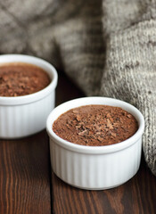 Chocolate vegan dessert - aquafaba mousse - egg free, non-dairy cocoa pudding or souffle  on rustic cottagecore background of woolen handmade sweater, closeup, vegan and vegetarian food concept