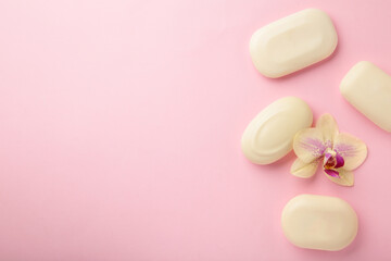Different white soaps with flower. A lot of solid soap for hygiene and cleanliness on a pink background.