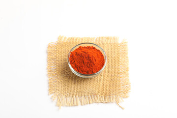 Red chilli powder in glass bowl on white background.