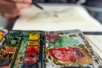 Close-up of a watercolor palette with different colors