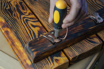 Wooden Key Holder For The Wall and a hand with screwdriver.