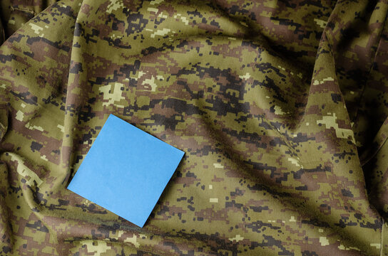 A fragment of a crumpled camouflage military uniform and a blue