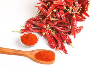 Fototapeta premium Dried red chilli and red chilli powder in glass bowl and wooden spoon on white background